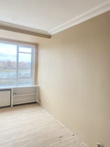 Lyst rum med trægulv og stort vindue